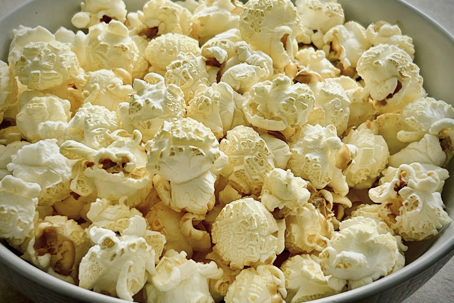A warm bowl of freshly popped popcorn, ready to share on a party table